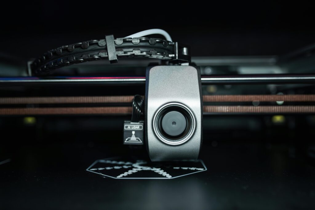 pexels-photo-20877039-20877039 Detailed close-up of a 3D printer extrusion head in focus, showcasing modern technology.