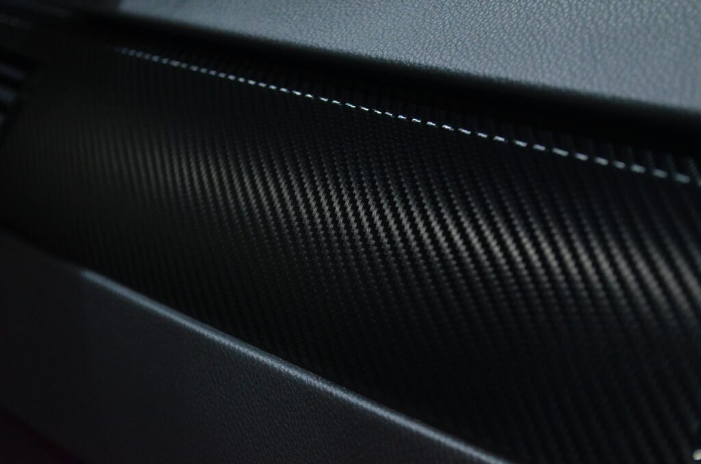 pexels-photo-596815-596815 Detailed view of a carbon fiber texture on a car interior showcasing modern design.