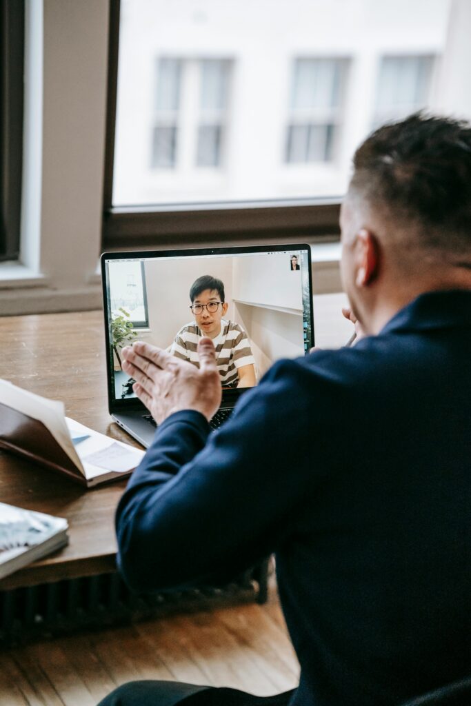 Business professional having a video call at the office with a colleague using a laptop.